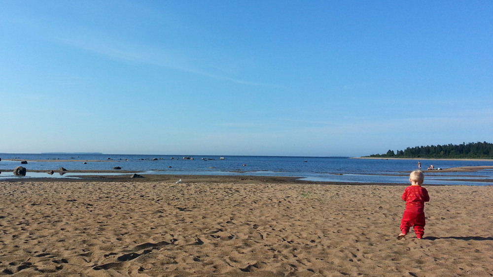 Ett barn på en sandstrand.