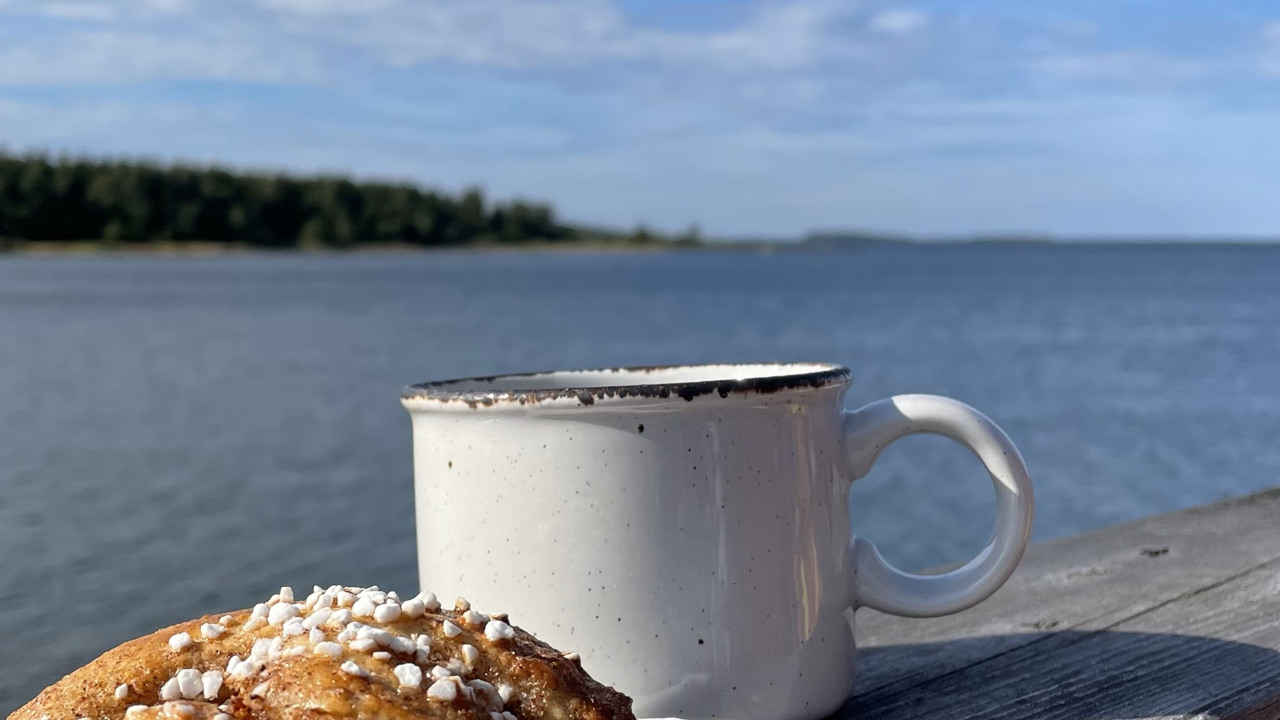 Kanelbulle, kaffekopp och hav>
