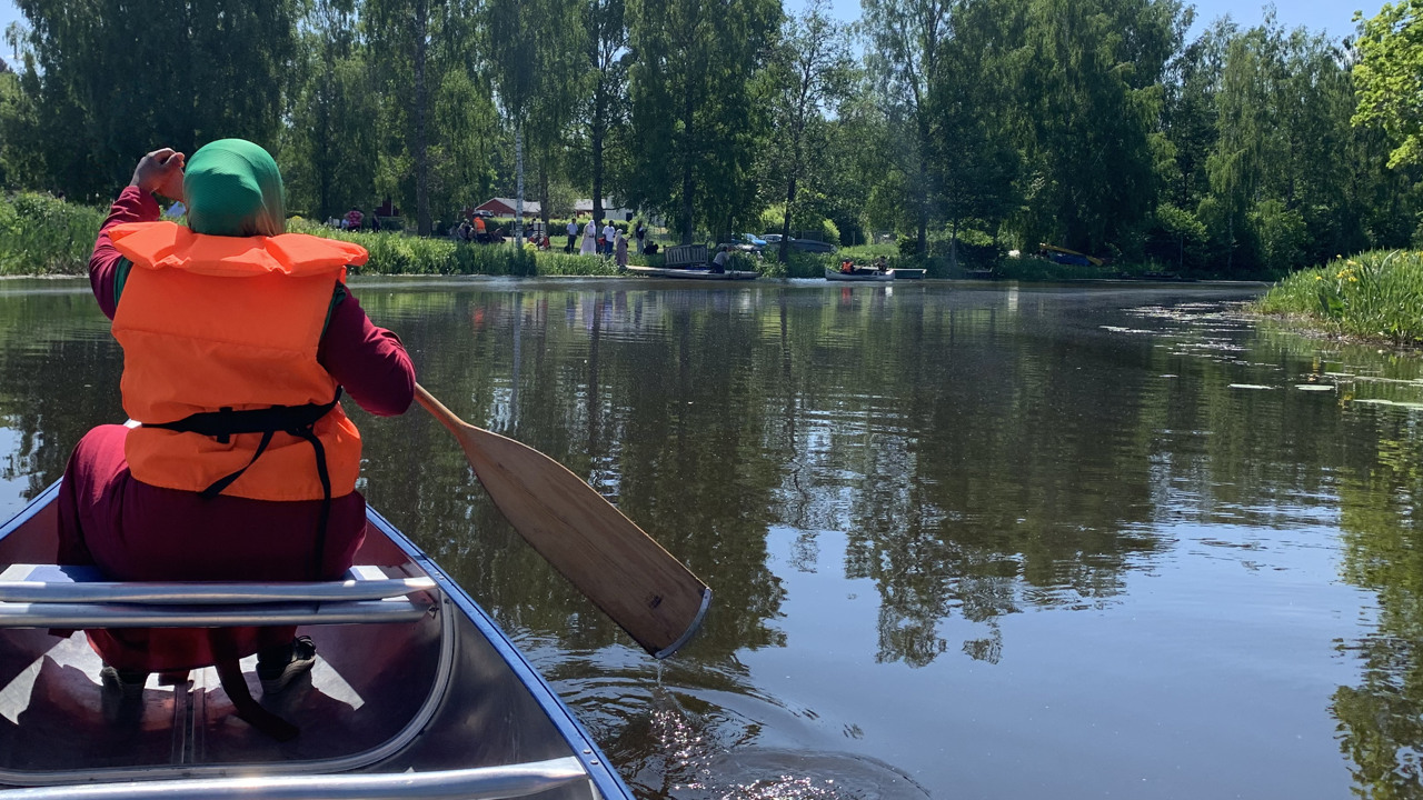 Kvinna med slöja paddlar kanot>