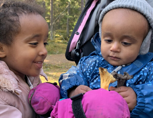 Två små barn som håller i varsin svamp