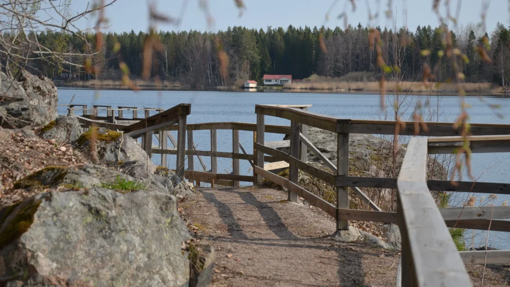 En gångväg längs vattnet, med staket på sidan.