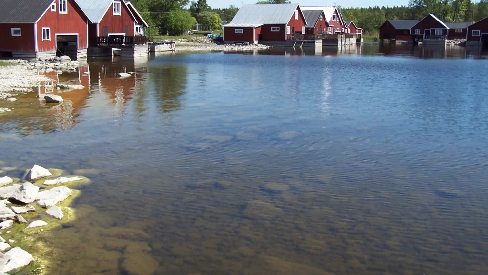 Röda sjöbodar längs vattnet.