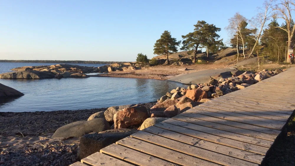 Gångväg av trä längs havet.